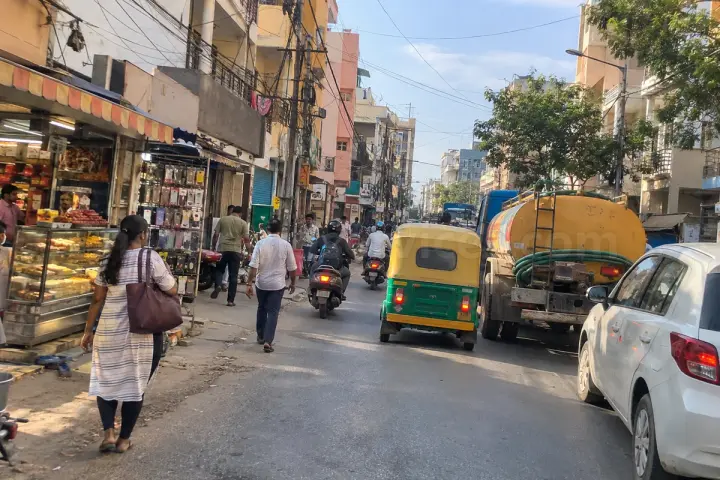 Busy main road in Hongasandra with shops, autos and a water tanker