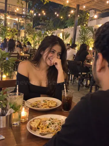 Woman laughing on a dinner date at a Bangalore cafe
