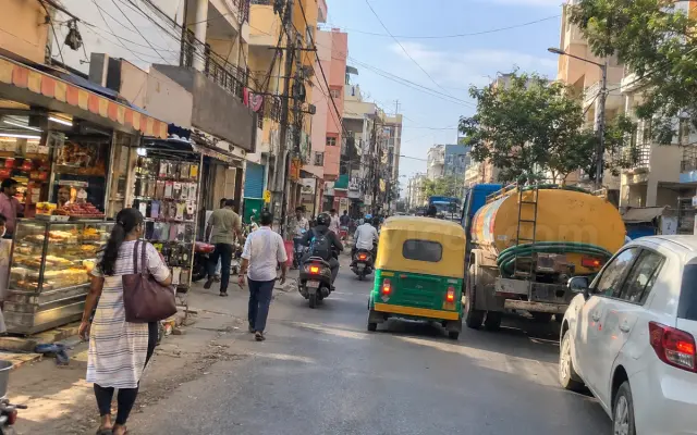 Busy main road in Hongasandra with shops, autos and a water tanker