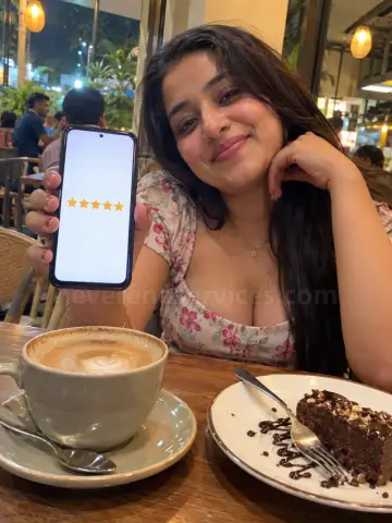 Woman showing five stars on her phone at a cafe table